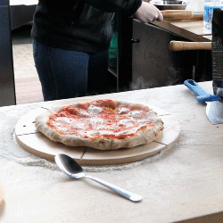 Le chef coupe la pizza avec une roulette