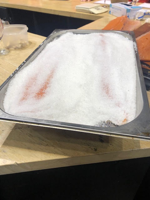 Saumon salage à sec dans un bac en inox